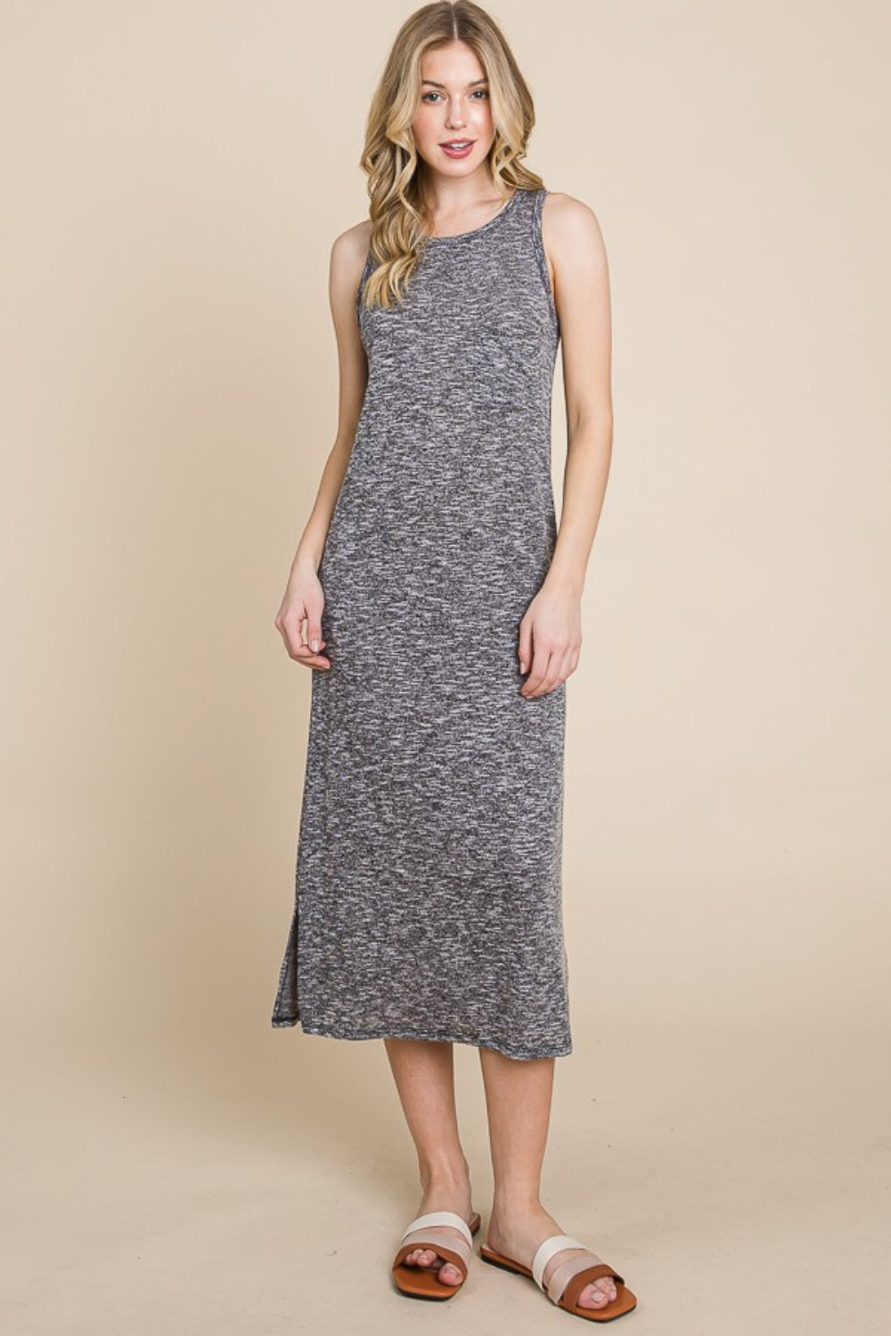 A person with long hair wears the chic BOMBOM Round Neck Slit Midi Tank Dress, ideal for a summer wardrobe. Standing on a neutral background, theyre paired with white and brown slide sandals. Their hands rest by their sides, showcasing a slight smile.