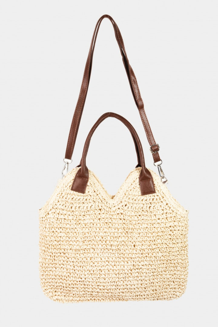 The Fame Straw Braided Faux Leather Strap Shoulder Bag is a beige tote with two brown leather handles, a detachable faux leather shoulder strap, and is displayed on a plain white background.