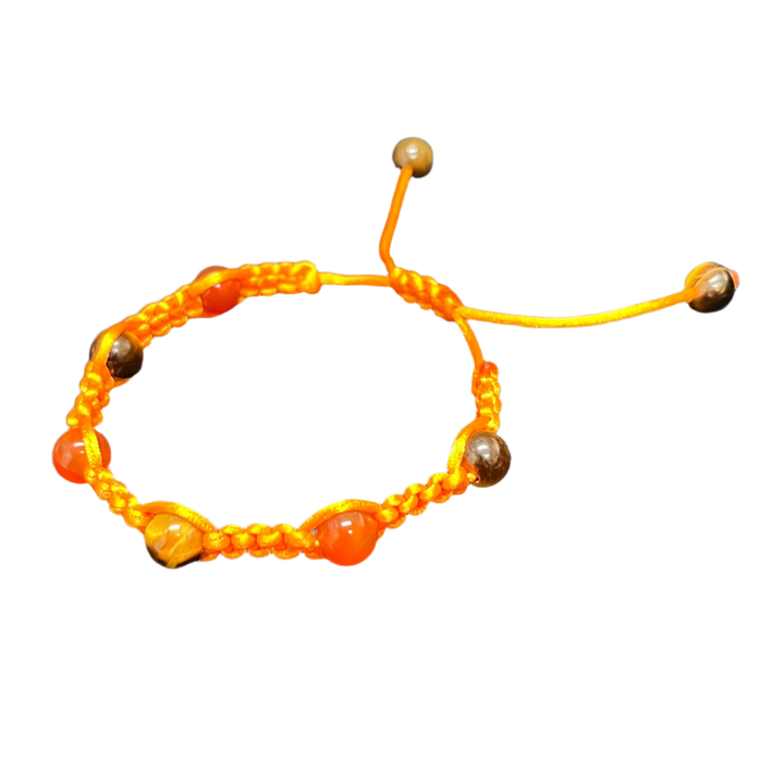 The Gem and Stone Beach Bracelets by Claire are exquisitely handcrafted with orange thread and beads, showcasing a knotted design with adjustable ends, making them the perfect accessory displayed on a black fabric background.