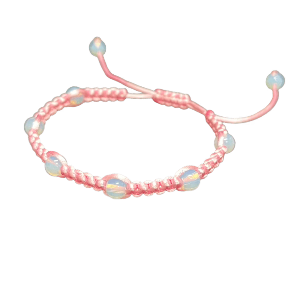 The Gem and Stone Beach Bracelet by Claire is a one-of-a-kind accessory, featuring iridescent round beads evenly spaced along a delicate pink macramé braided cord. It includes an adjustable closure with bead-tipped ends, and its handcrafted design is beautifully accented against a solid black background.