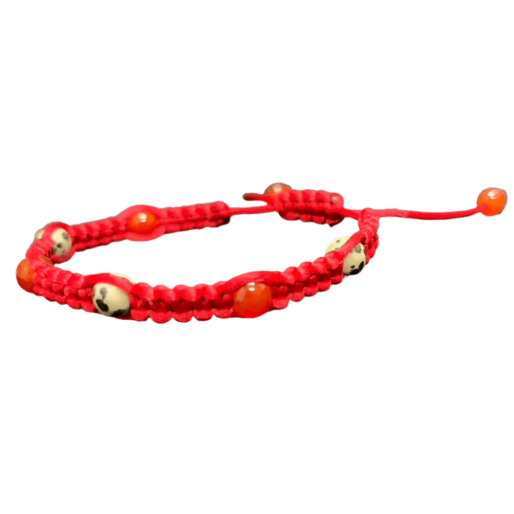 The Gem and Stone Beach Bracelet by Claire is a unique accessory, featuring a distinctive red cord enhanced with white beads decorated with black skull designs and vivid orange accents. This handcrafted bracelet includes an adjustable pull string, capturing the essence of distinctive gemstone jewelry and making it an ideal addition to any outfit.