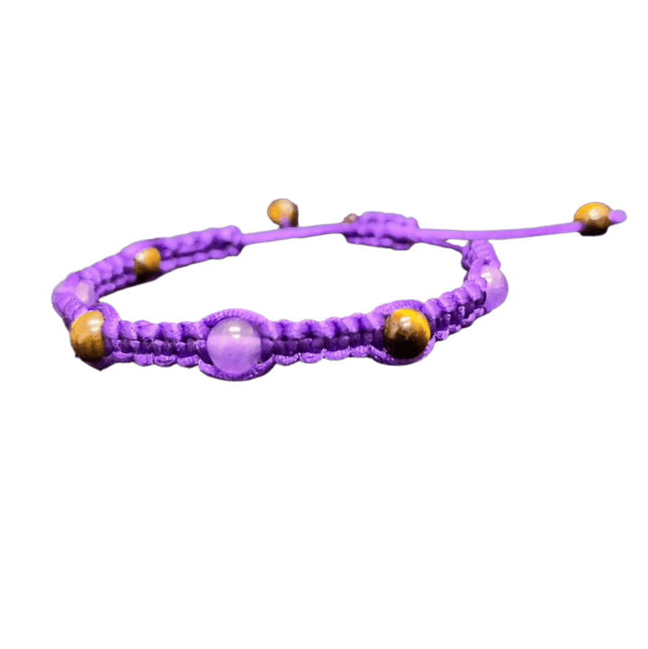 Introducing the Gem and Stone Beach Bracelets by Claire, this unique purple braided macrame bracelet showcases alternating purple and brown round beads. Set against a black background, its intricate design and vibrant colors truly stand out.