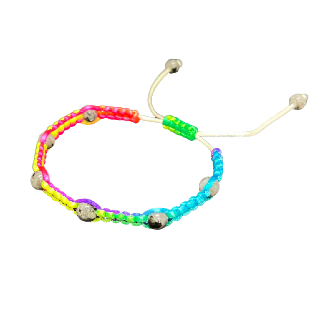 The Gem and Stone Beach Bracelets by Claire feature vibrant sections of neon pink, orange, yellow, green, and blue intricately woven with small metallic beads. This handcrafted bracelet is set against a black background that enhances its lively colors and includes an adjustable white cord for the perfect fit.