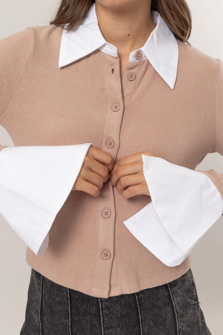 The focus is on the clothing details as a person wears the versatile HYFVE Collared Contrast Button Down Crop Knit Cardigan with its large white cuffs and collar over a dark skirt.