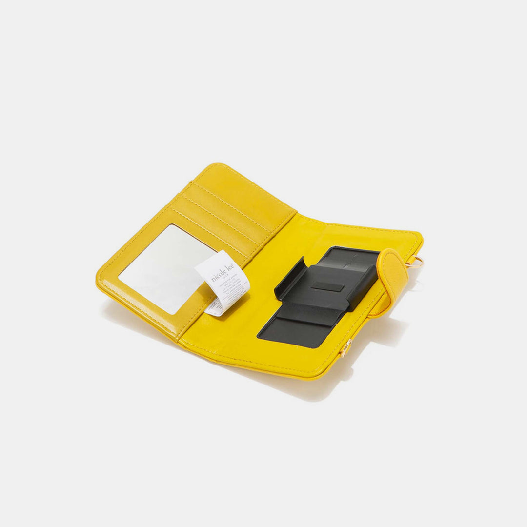 An open Nicole Lee USA 2 Piece Phone Case Crossbody Wallet displays its yellow vegan leather interior with card slots, a clear ID window, and a black organizing section. A small paper slip is peeking out from one compartment, combining style with functionality.