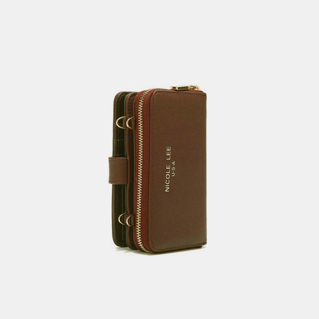 The Nicole Lee USA 2 Piece Phone Case Crossbody Wallet is a brown vegan leather crossbody featuring gold zippers and a wrist strap. It has the brand name in gold letters on the front and offers multiple compartments for convenience.