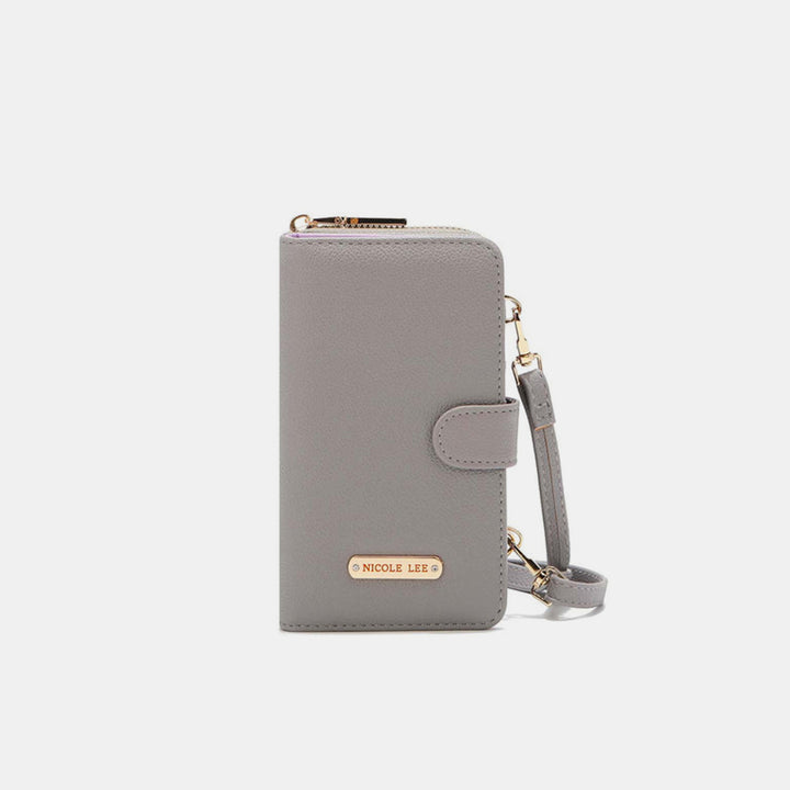 The Nicole Lee USA 2 Piece Phone Case Crossbody Wallet is a gray vegan leather wallet featuring a detachable wrist strap, zippered top, gold label on the front, and snap closure for added security. Displayed against a plain white background.