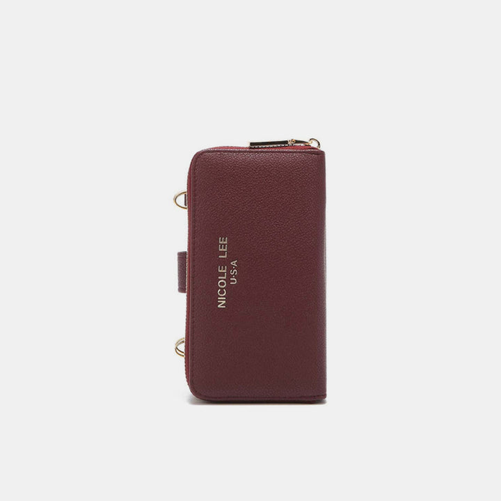 The Nicole Lee USA 2 Piece Phone Case Crossbody Wallet is maroon vegan leather with gold accents and NICOLE LEE U.S.A embossed on the front. It has a zip closure, small metal hardware on the sides, and doubles as a chic phone case against a light gray background.