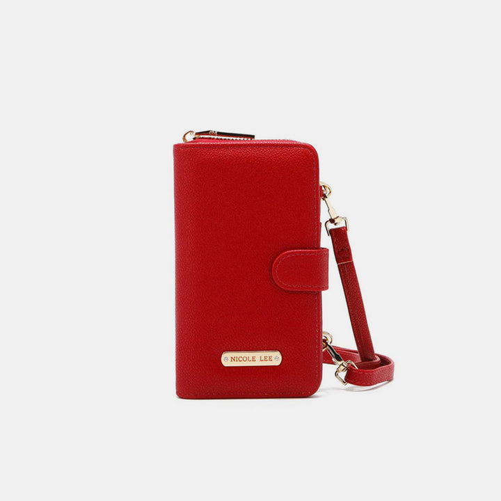 The Nicole Lee USA 2 Piece Phone Case Crossbody Wallet is a red vegan leather wallet with a detachable strap, featuring a flap closure with snap button and an engraved metallic label at the bottom, set against a plain white background.