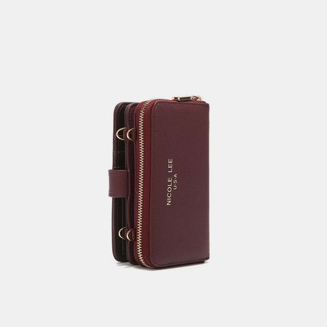 A maroon Nicole Lee USA 2 Piece Phone Case Crossbody Wallet crafted from vegan leather, featuring a gold zipper and side strap. The Nicole Lee USA logo is embossed in gold on the front, with gold rings, against a plain white background.