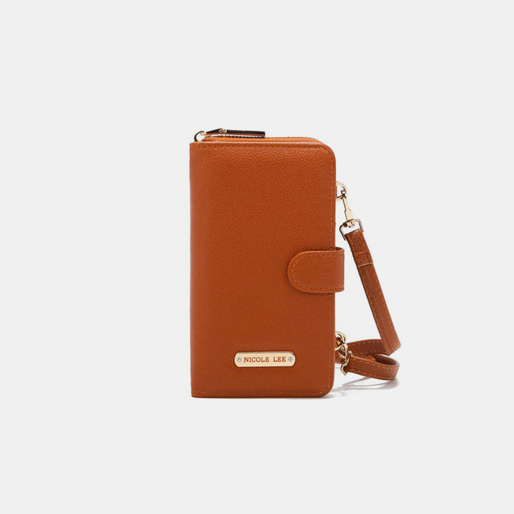 The Nicole Lee USA 2 Piece Phone Case Crossbody Wallet is a brown vegan leather accessory with a wrist strap and gold hardware, featuring a small front plaque. It has a zippered top and front strap closure, elegantly displayed against a plain white background.