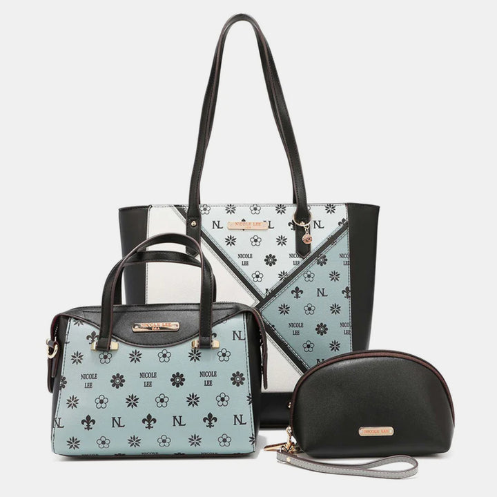 The Nicole Lee USA 3-Piece Color Block Handbag Set includes a large tote, medium satchel, and small wristlet in vegan leather with a black and light blue color block design, accented by floral and logo patterns.