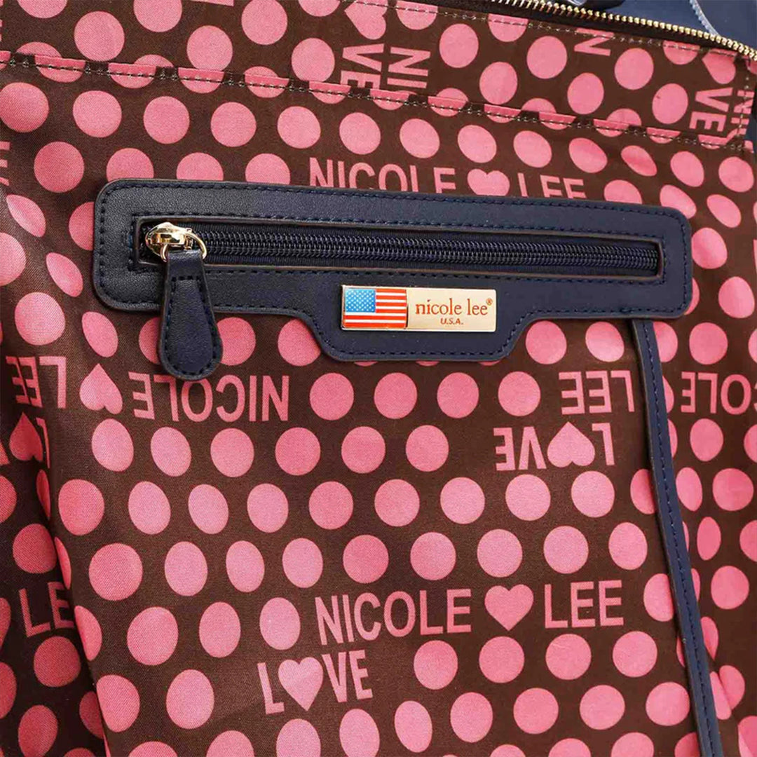 A close-up of a Nicole Lee USA 3-Piece Color Block Handbag Set shows pink polka dots on brown vegan leather, featuring a zipper pocket and an American flag label with NICOLE LOVE and NICOLE LEE in pink text.