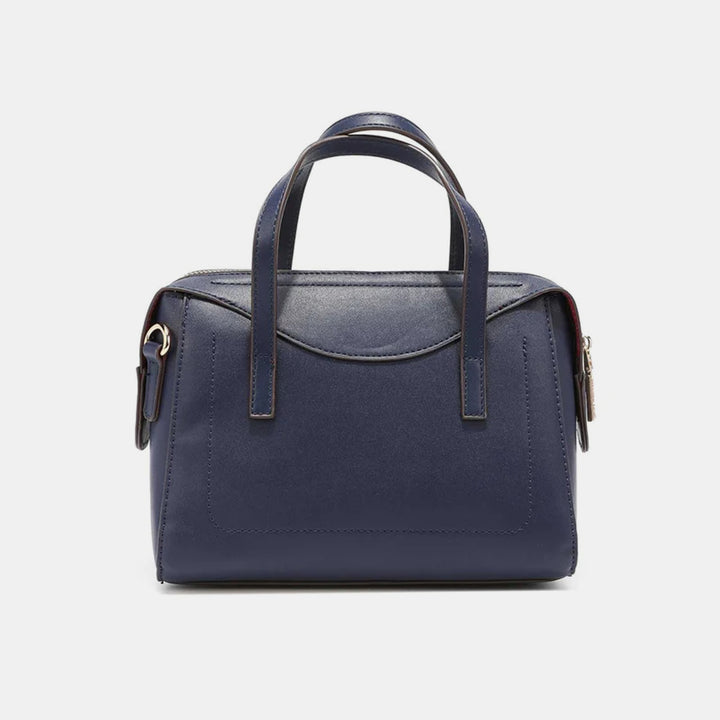 The Nicole Lee USA 3-Piece Color Block Handbag Set includes a navy handbag with two handles, a detachable shoulder strap, and minimalist stitching details on a plain white background, complete with a zip closure.