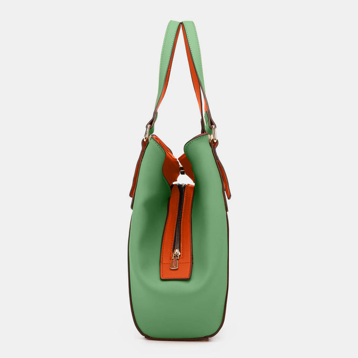 The Nicole Lee USA Contrast Polka Dot Handbag showcases a side view of a stylish, spacious design with green and orange panels. Made from vegan leather, it features a top zipper closure and matching green handles for functionality and flair.