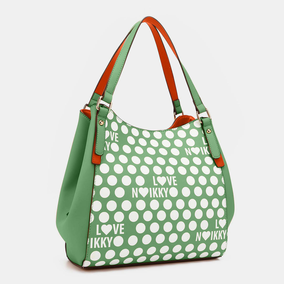 The Nicole Lee USA Contrast Polka Dot Handbag is a chic green bag with white polka dots and LOVE NIKKY in a repeating pattern, featuring orange accents on handles and sides. Made from vegan leather, its stylish and spacious design combines playfulness with elegance.