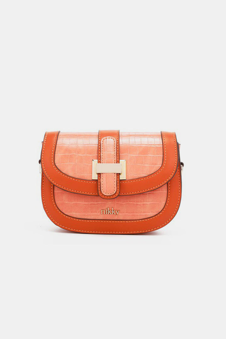 The Nicole Lee USA Croc Embossed Crossbody Bag is an eco-leather crossbody featuring a stunning orange and peach croc-embossed design. It includes a flap closure, decorative buckle, and proudly showcases the Nikky brand name embossed on the front.