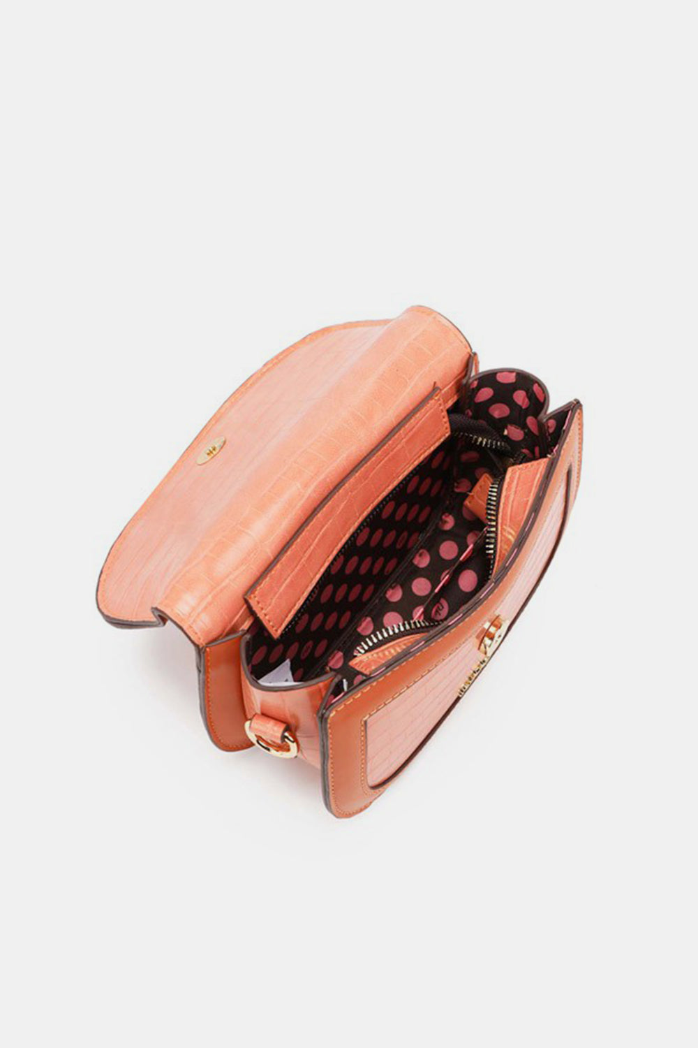 Introducing the Nicole Lee USA Croc Embossed Crossbody Bag, an elegant accessory in a striking open coral hue, crafted from eco-leather. It features a playful polka dot interior lining and is designed with a flap closure, multiple compartments, and a zipper pocket for both style and practicality.