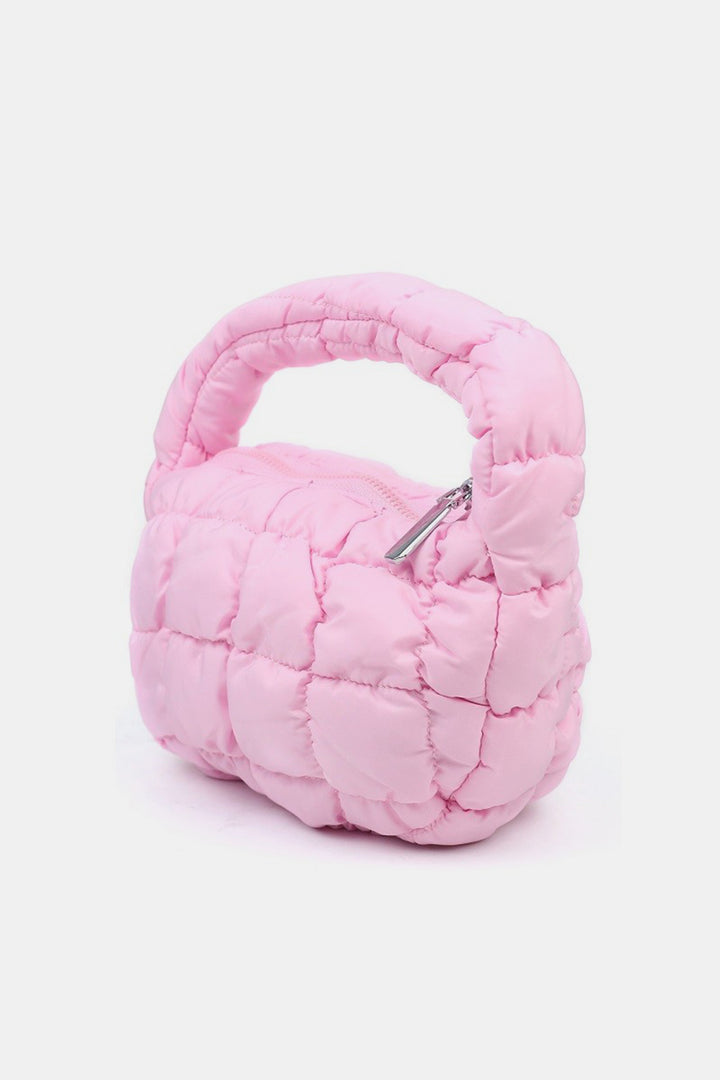 The Zenana Quilted Micro Puffy Handbag is a stylish accessory that showcases a compact quilted pink design with a rounded handle and a top zip closure, elegantly contrasted against a plain white background.